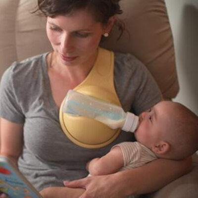 Molanizzi Bottle Holder: Hands-free baby feeding. Woman using the yellow bottle holder to feed baby.