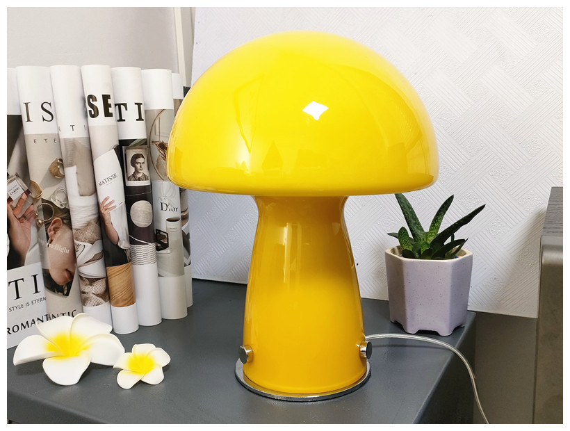 Yellow Molanizzi mushroom table lamp next to white flowers and a potted plant
